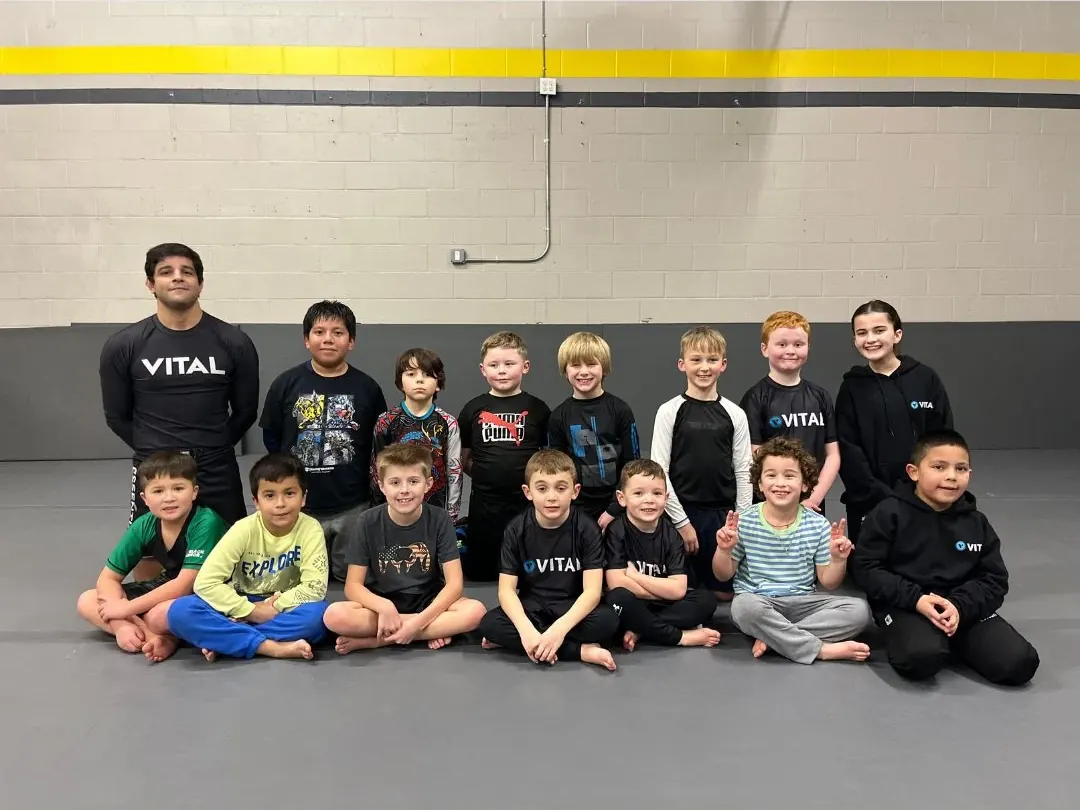 The Vital Jiu Jitsu kids class smiling with their coach